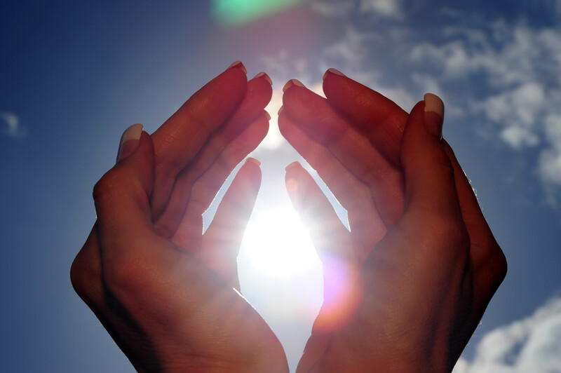 Woman's hands with the sun behind them